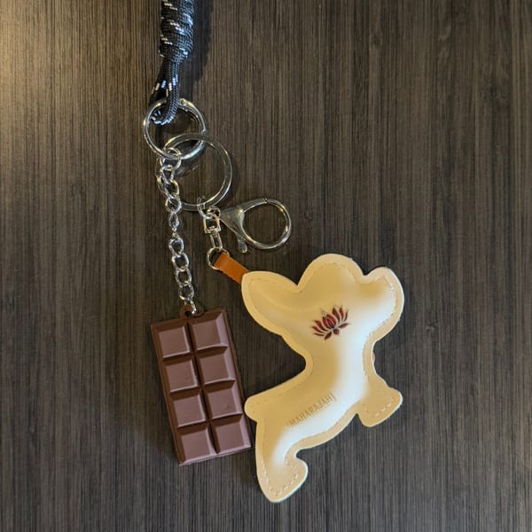 Maharajah India Cuisine keychain with a chocolate bar charm and a lotus flower logo.