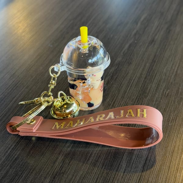 Maharajah India Cuisine keychain with a miniature bubble tea cup and a pink strap.