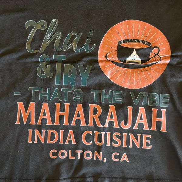 Black t-shirt with "Thai & Try - That's The Vibe Maharajah India Cuisine Colton, CA" in orange and teal.